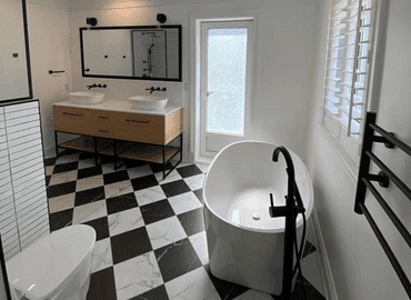 Salle de bain terminée : bain autoportant avec robinet sur pied et vanité à deux vasques